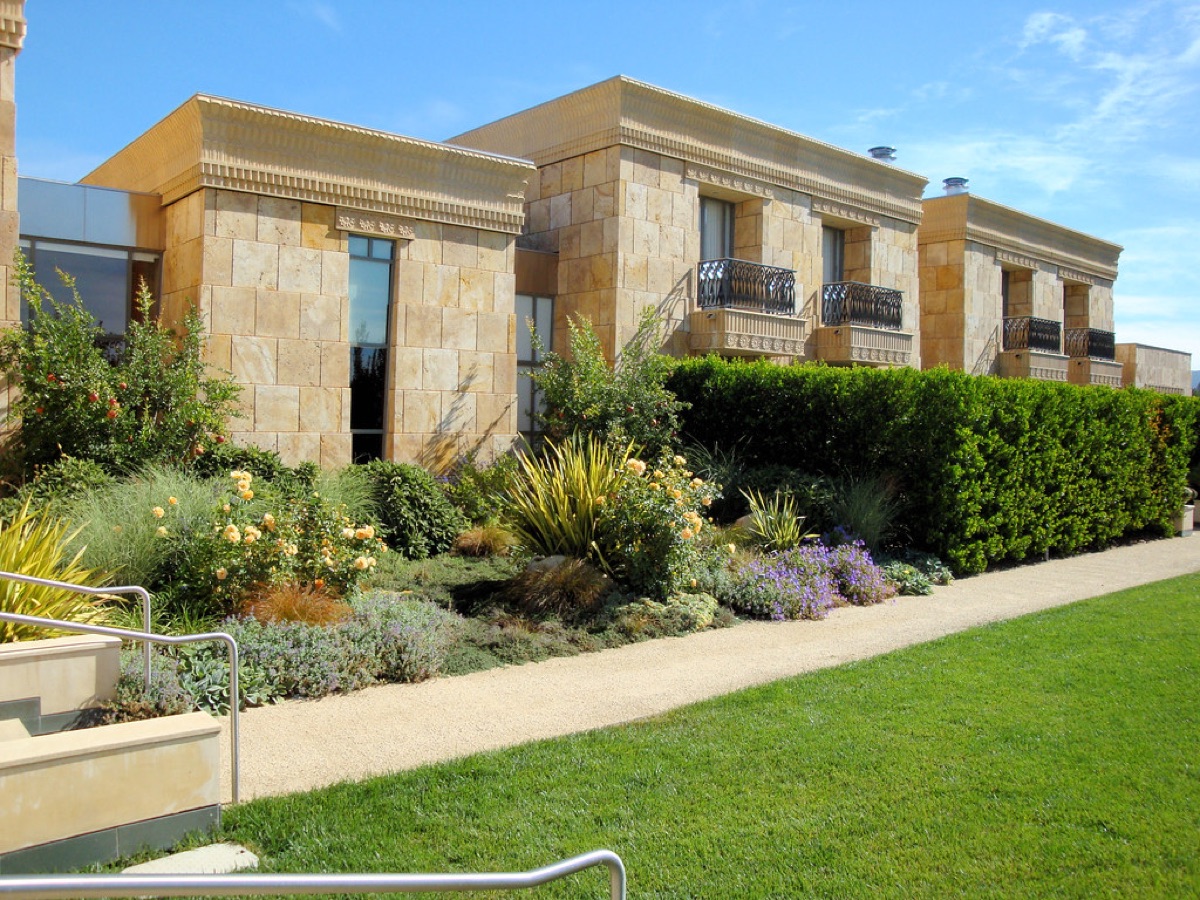 california winery exterior with vineyards and red wine barrels
