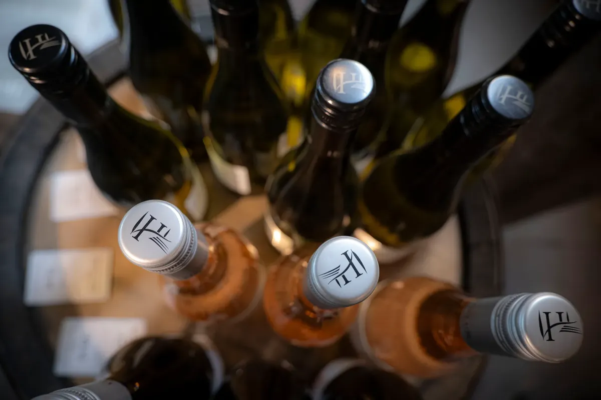 An artistic top view photo of various wine bottles arranged on a wooden table.