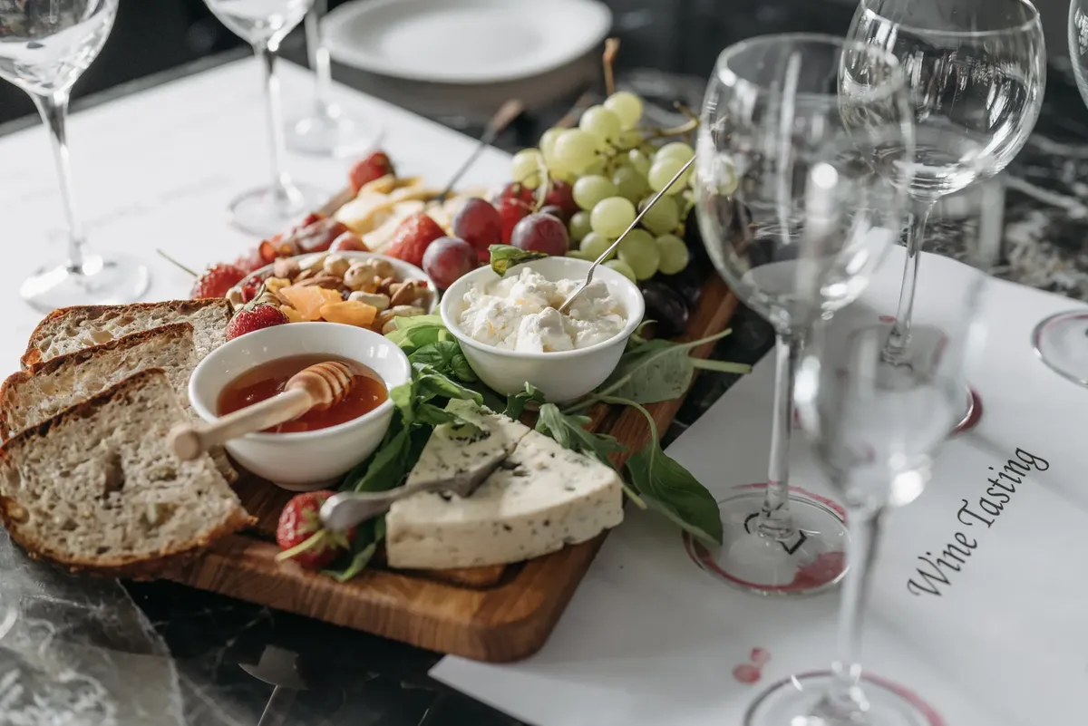 A delicious spread of cheeses, fruits, and bread on a charcuterie board, ready for wine tasting.
